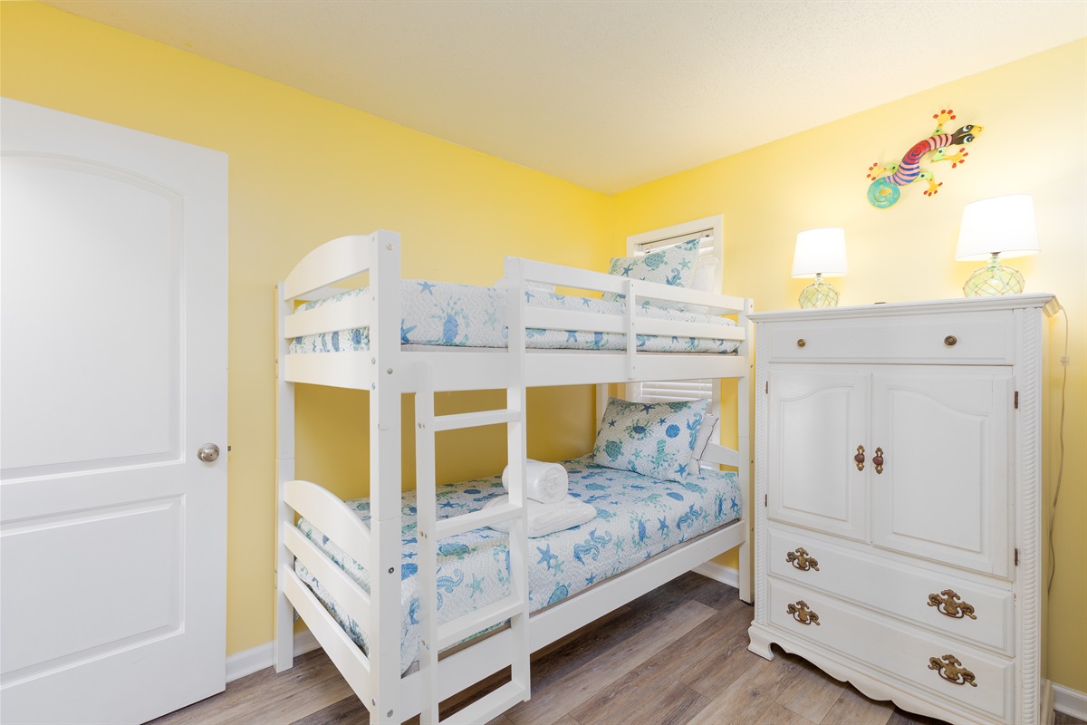 Bunk bedroom is furnished with a spacious dresser