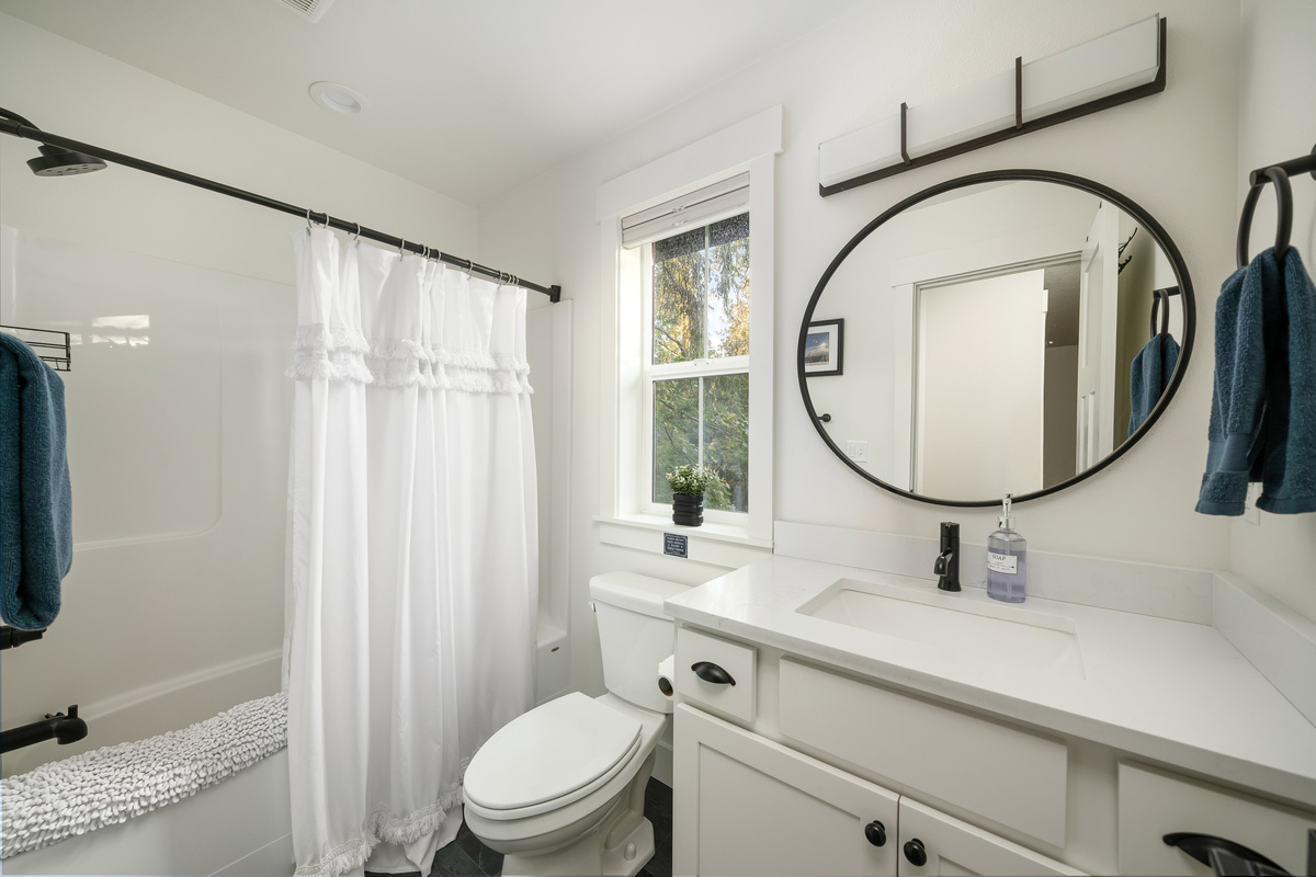Soak or shower — this bath does both, with the woods just outside the window.