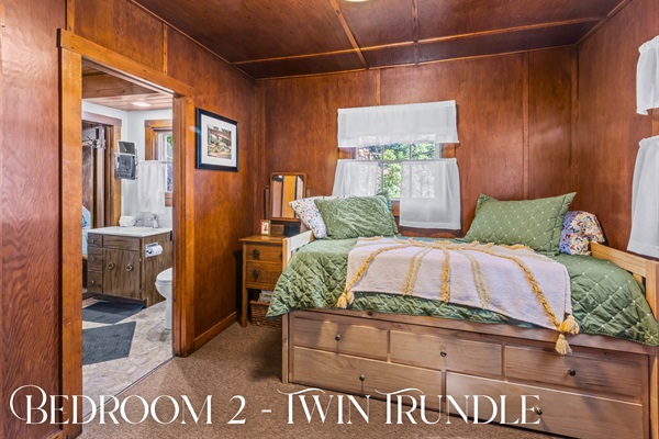 Bedroom 2’s twin trundle bed and vintage decor create a cozy space for kids or extra guests.