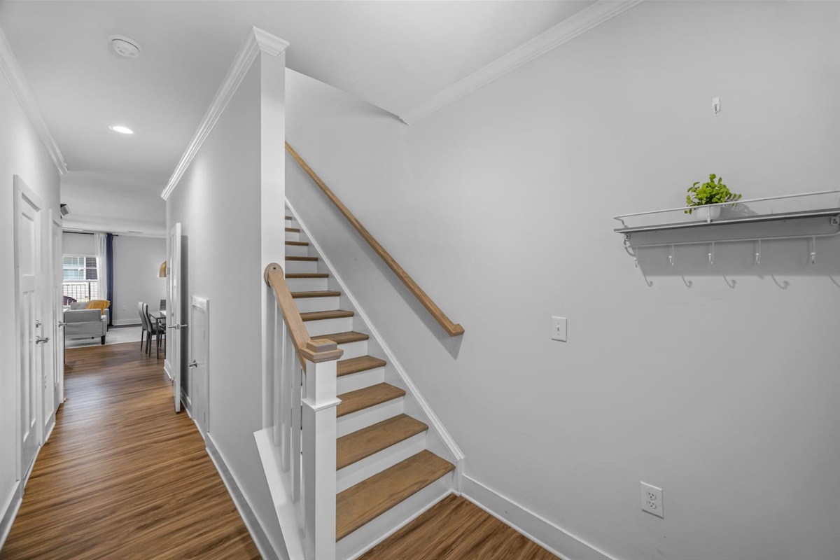 A warm welcome with wood flooring, bright walls, and easy access to the upstairs bedrooms.