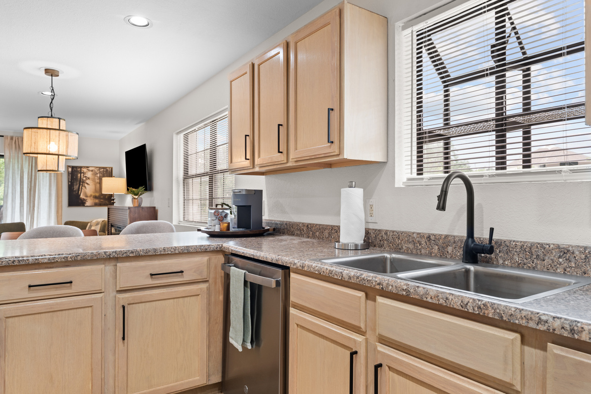 The kitchen includes a full-size refrigerator, dishwasher, cookware, dishes, and utensils.