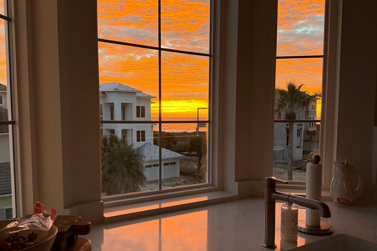 You’re making breakfast and the sunrise steals the show—gold light spilling across the counters while the ocean glows out the window. The kids wander in sleepy-eyed, and suddenly it feels like the best day of vacation is starting.
