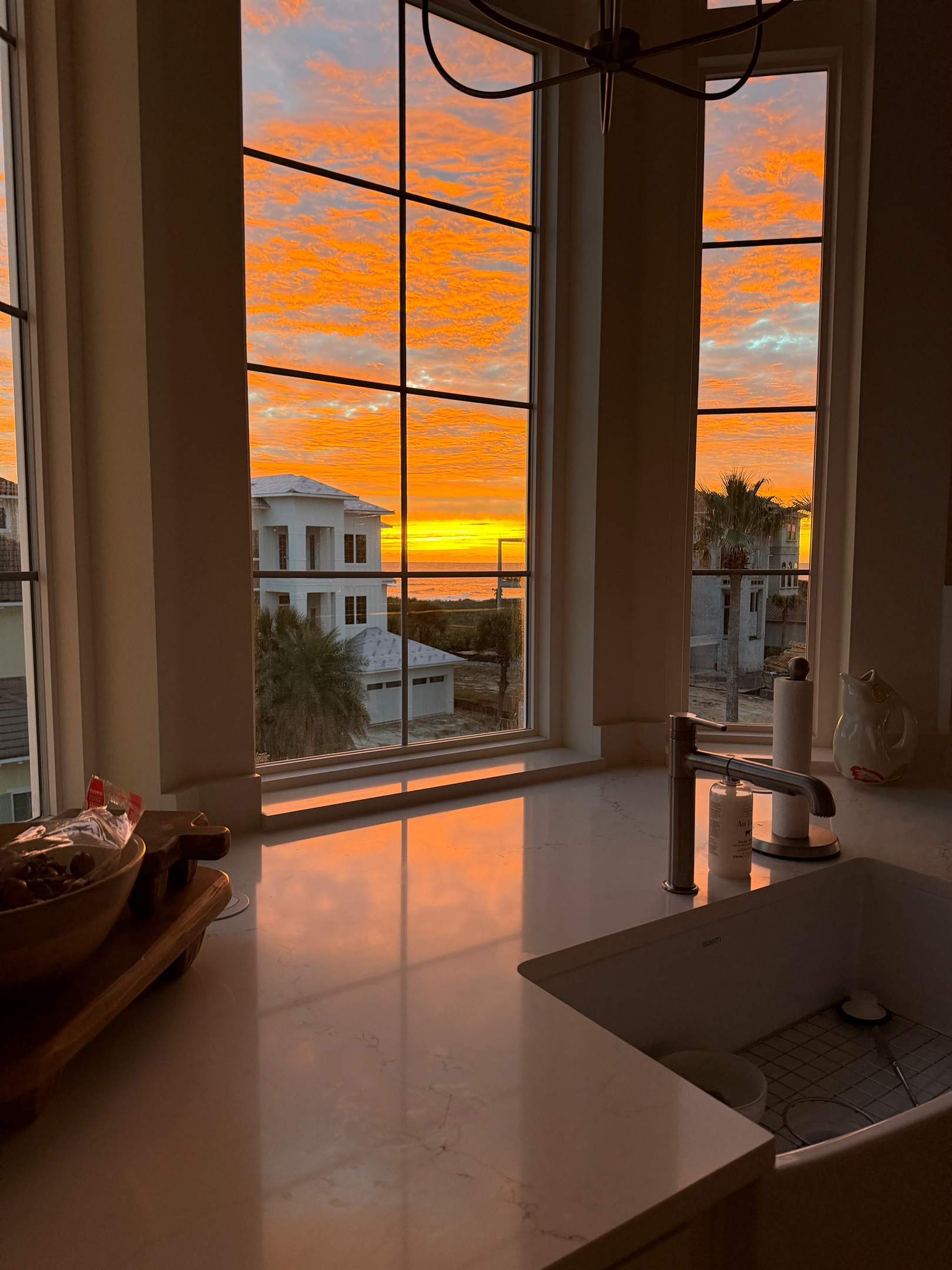 You’re making breakfast and the sunrise steals the show—gold light spilling across the counters while the ocean glows out the window. The kids wander in sleepy-eyed, and suddenly it feels like the best day of vacation is starting.
