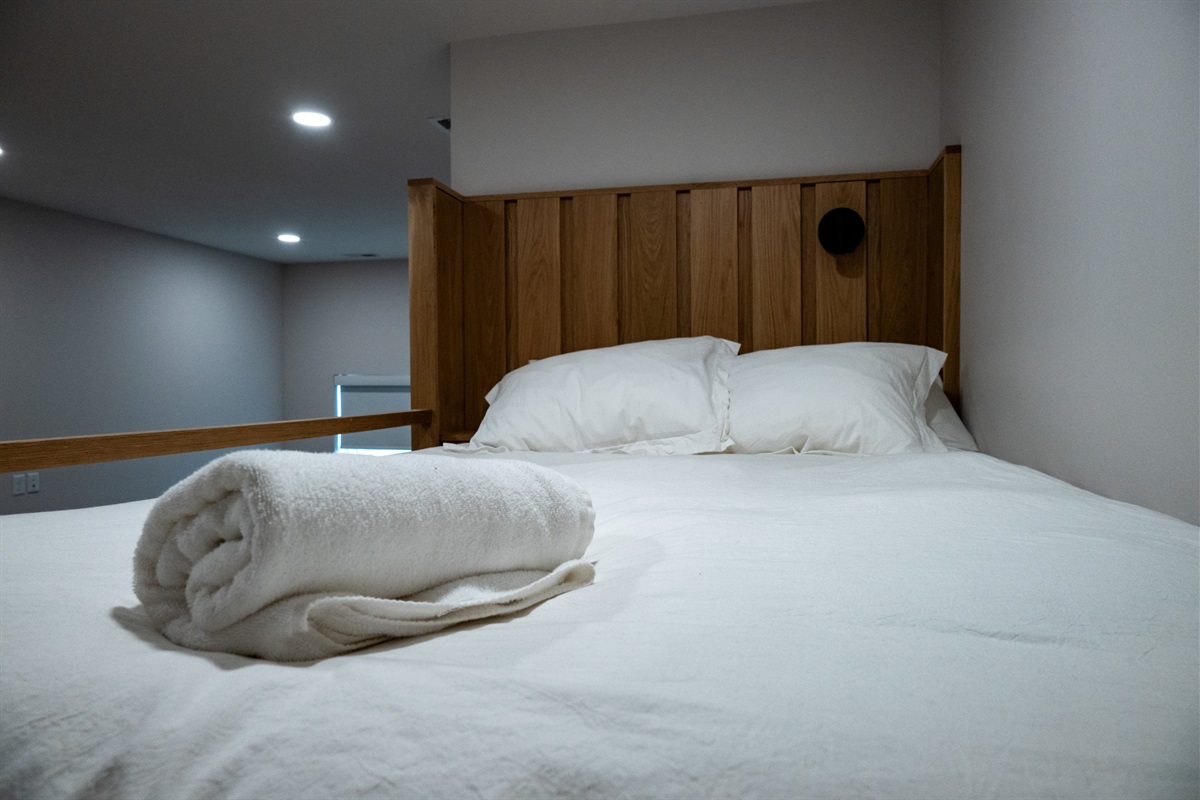Cozy lower-level bunk room with warm wood accents and plush bedding.