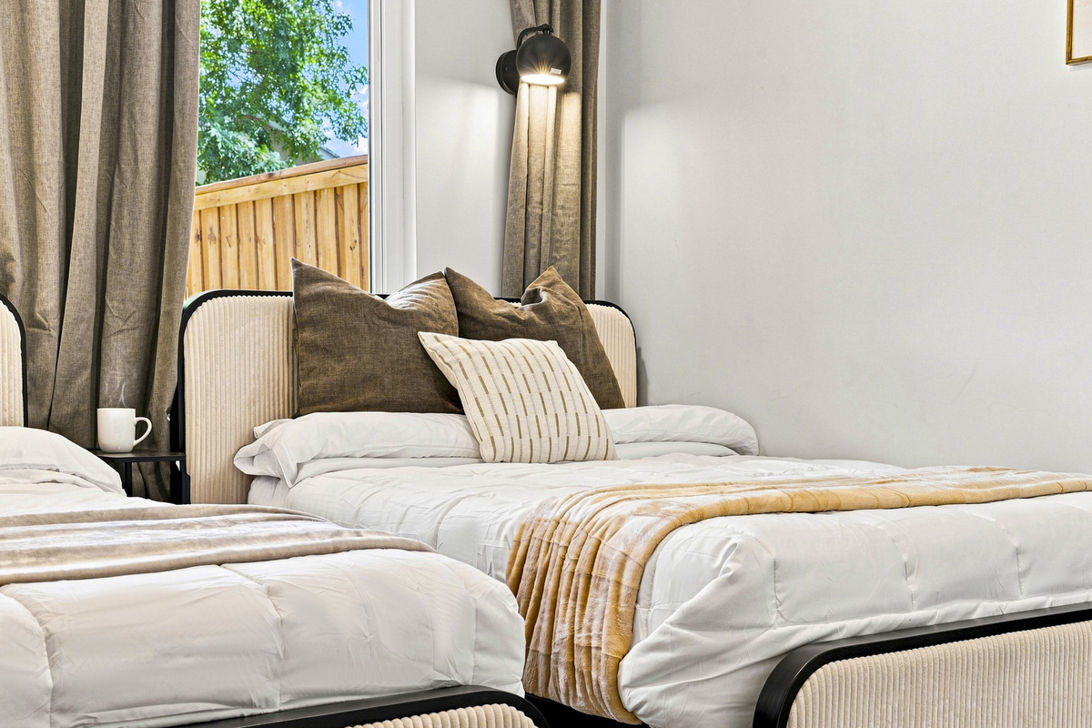 Stylish twin beds with plush pillows and natural light for a refreshing retreat!