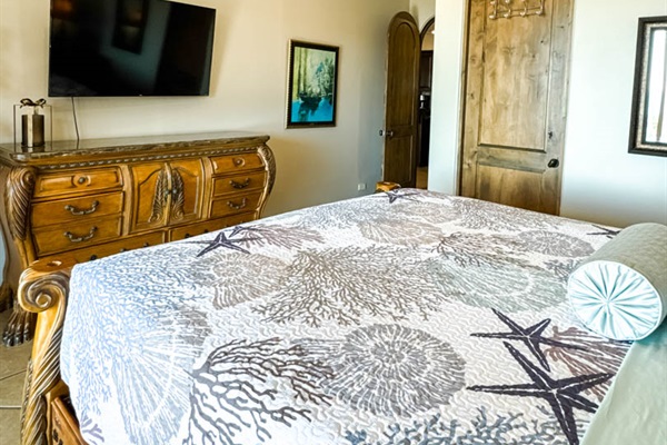 King bedroom with Smart TV, nightstands, and private patio access.