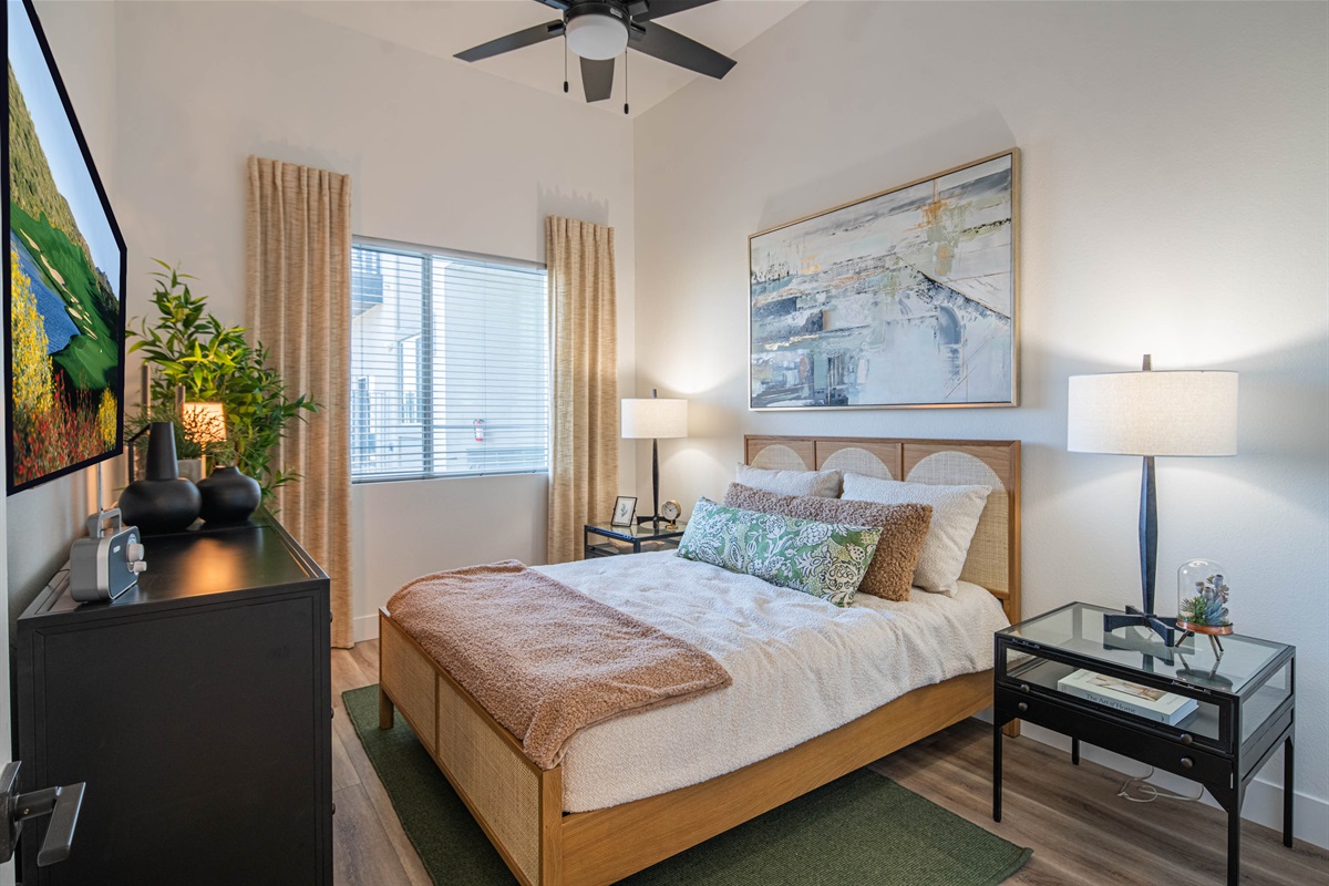 Queen bed. A cozy bedroom with soft, inviting decor, featuring a window that lets in natural light, creating a serene and restful atmosphere.