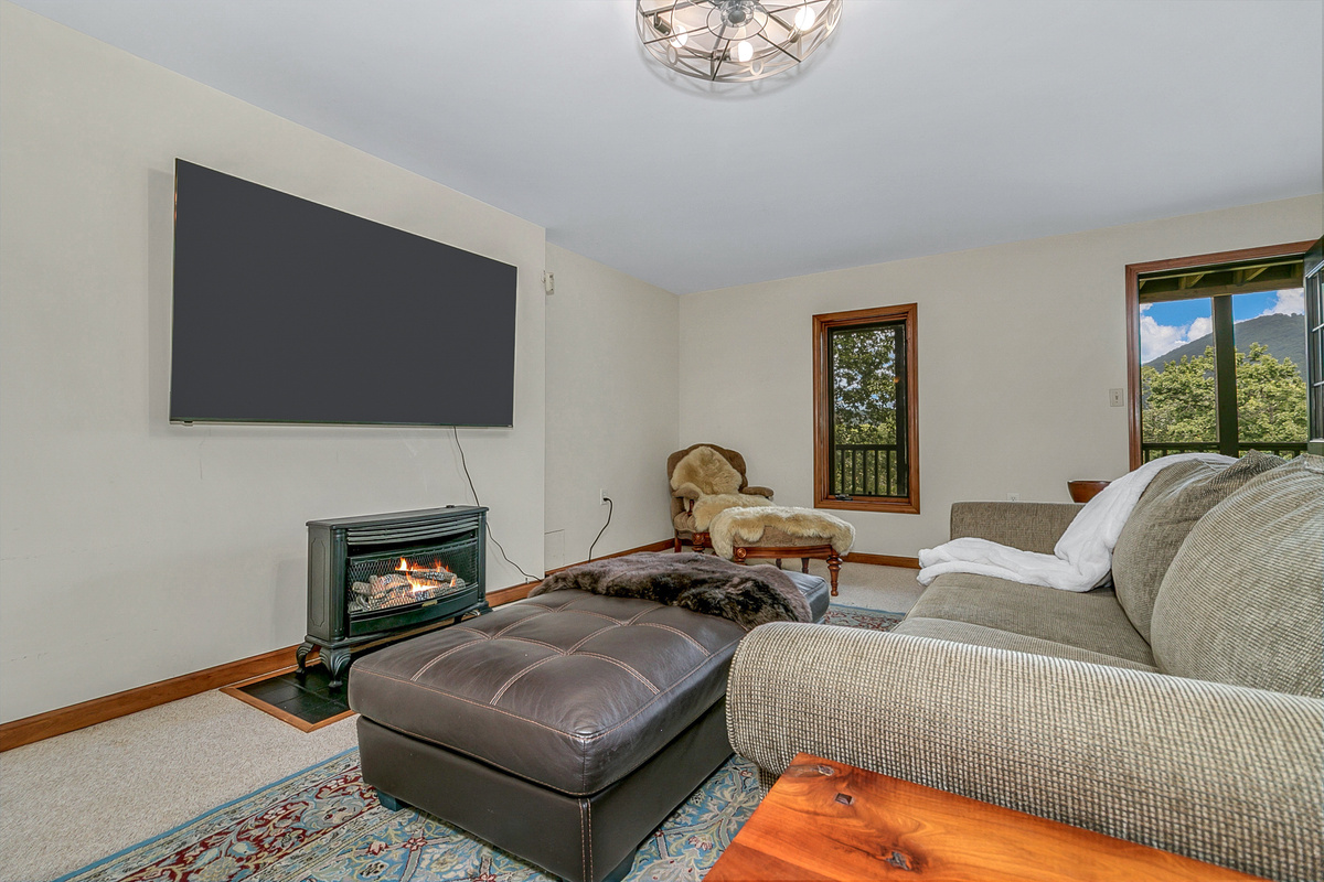 Basement Entertainment Room with Large Smart TV and Gas Fireplace