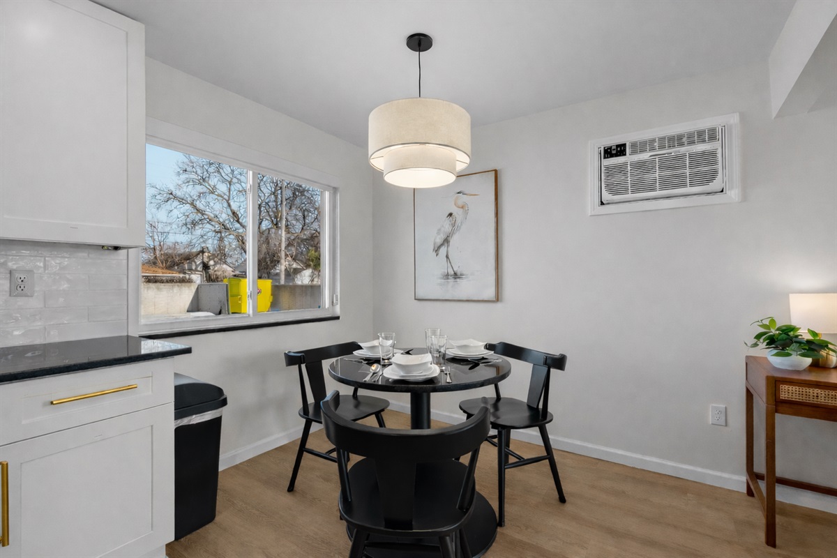 Charming dining nook with modern lighting, cozy seating for four, and natural light—perfect for shared meals, morning coffee, or casual evenings in.