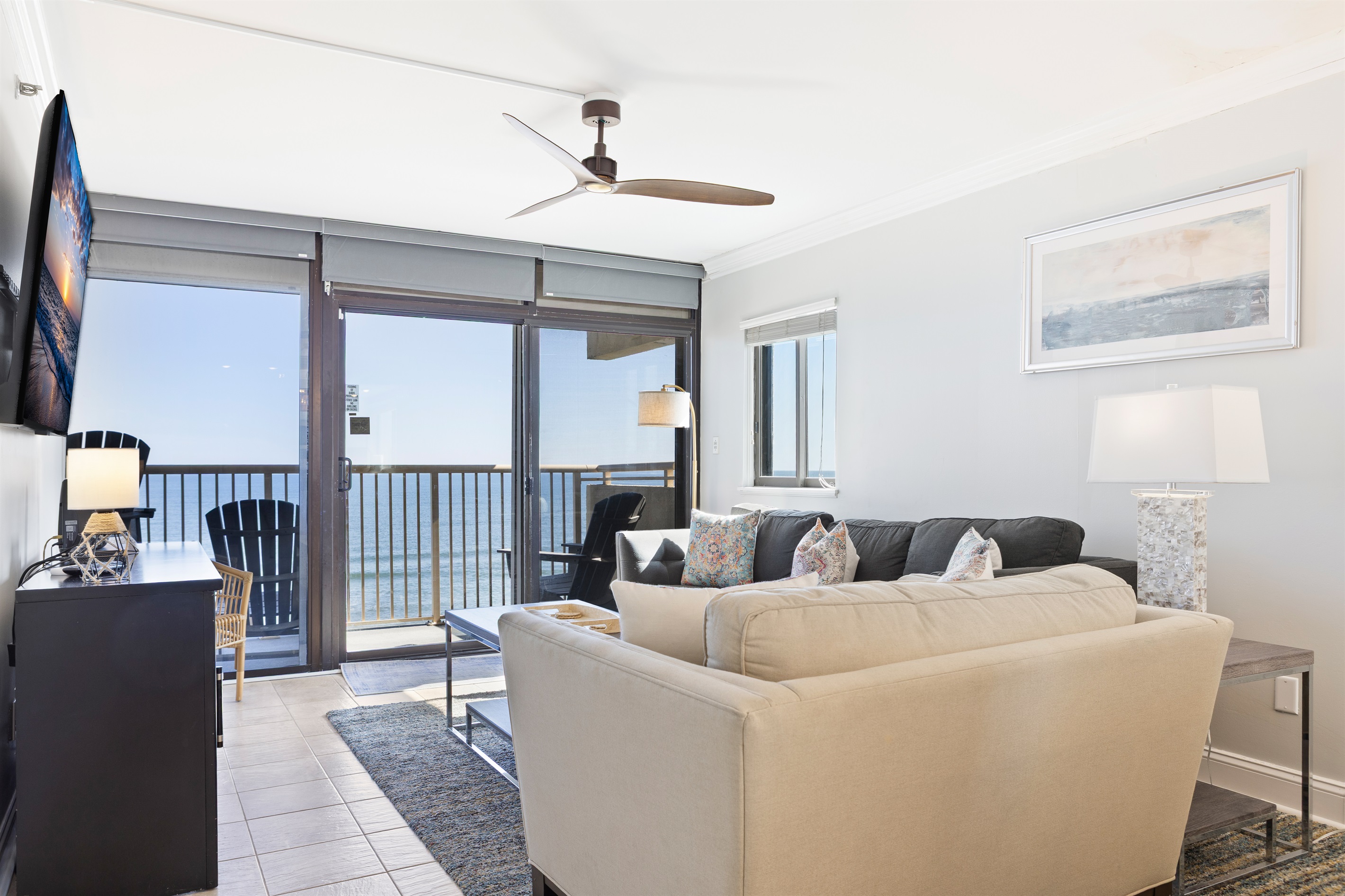 Living room with balcony access and ocean views