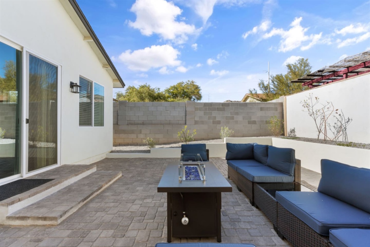 Outdoor living space with comfortable seating, grill, and a fire pit table for evening downtime.