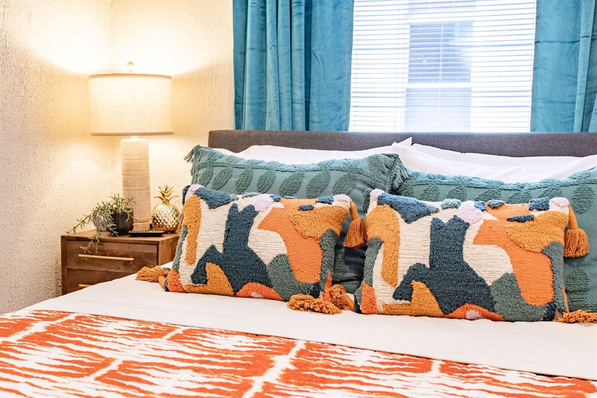 Bohemian-inspired bed with colorful, textured pillows, creating a cozy and artistic atmosphere that's perfect for relaxing and unwinding.