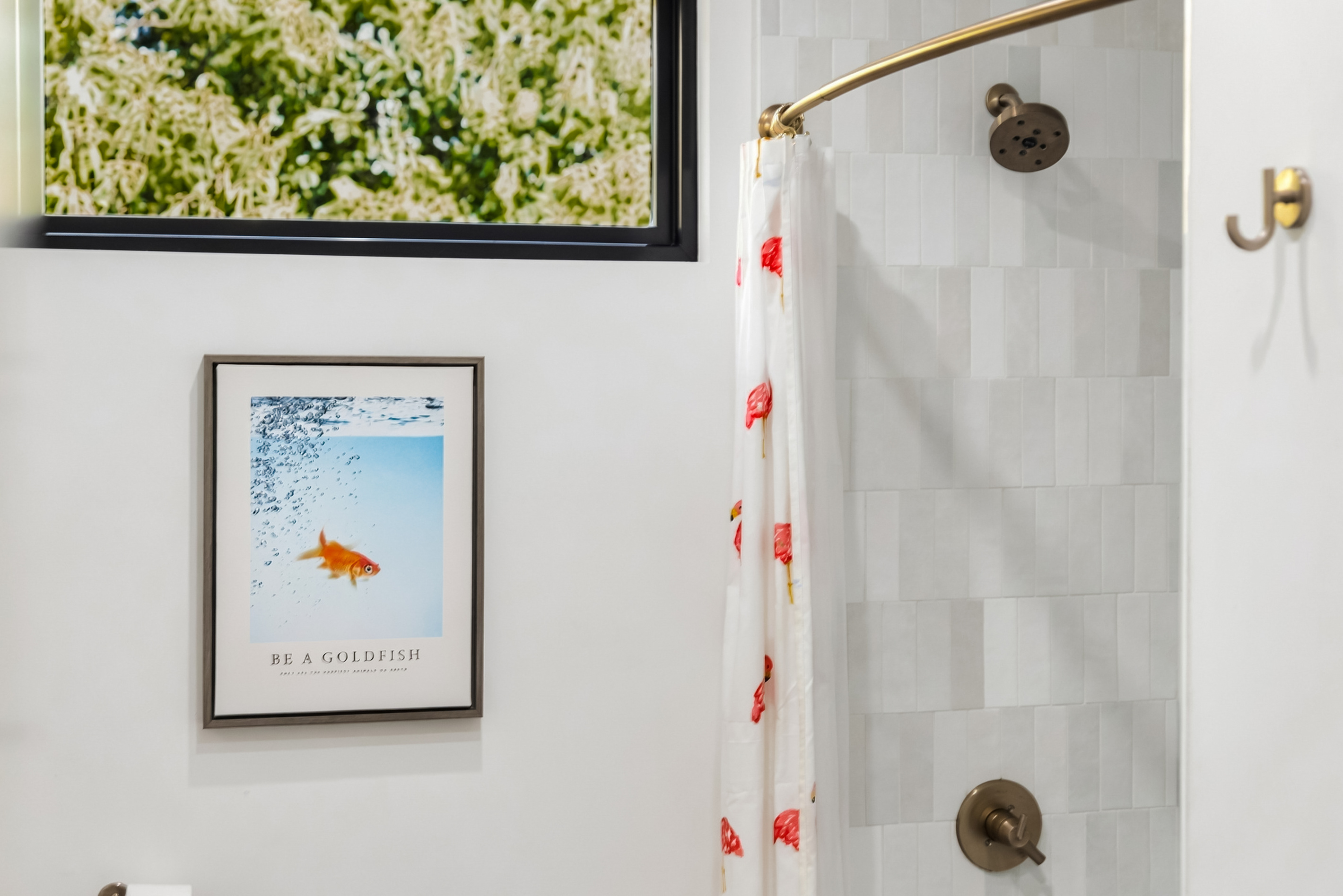 Tub/shower combo with playful art and a gold-finished shower system.