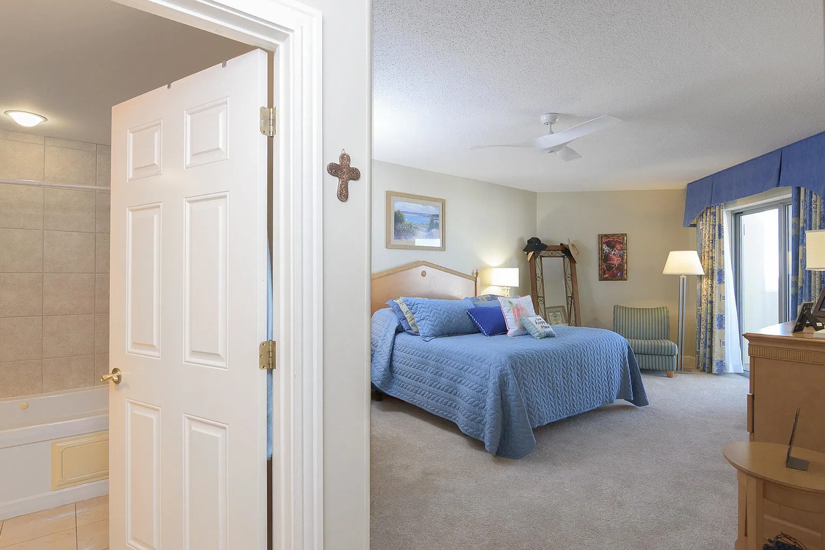 Spacious main bedroom with king bed, balcony access and ensuite