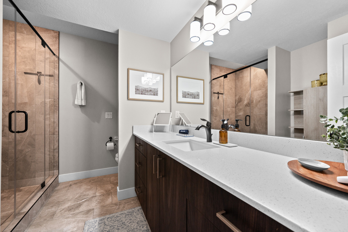 Elegant full bathroom featuring a dual-sink vanity, quartz countertops, and an oversized walk-in glass shower.