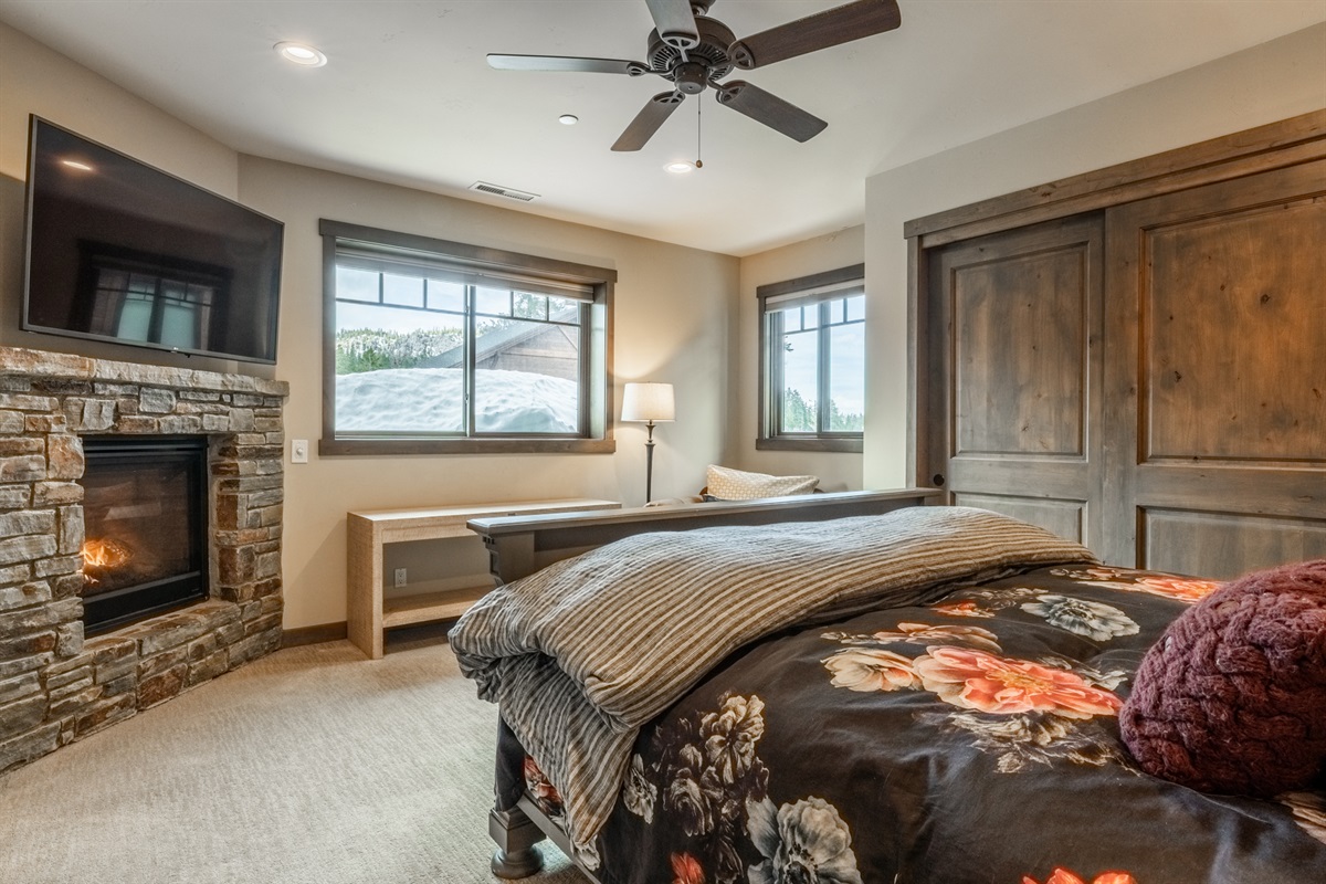 Fireplace warmth, oversized windows, and private ensuite access elevate this king retreat.