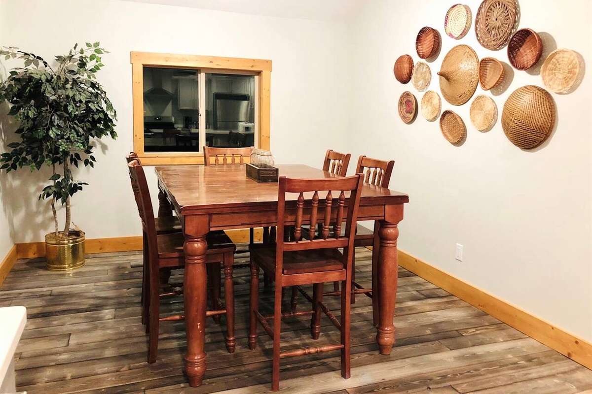 The dining area features natural lighting, charming decor, and a table that makes a great gathering spot for mealtimes and game nights.