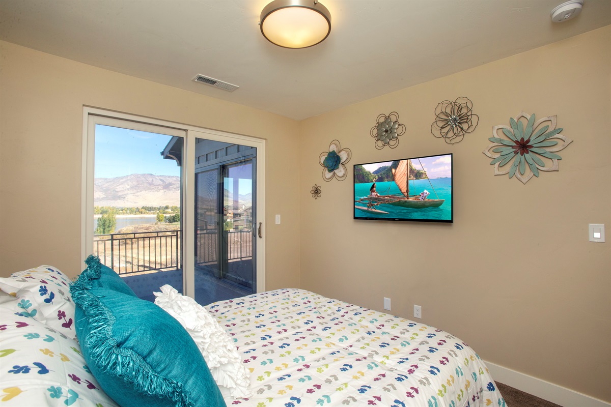 Cheerful bedroom with deck access and TV—perfect for guests.