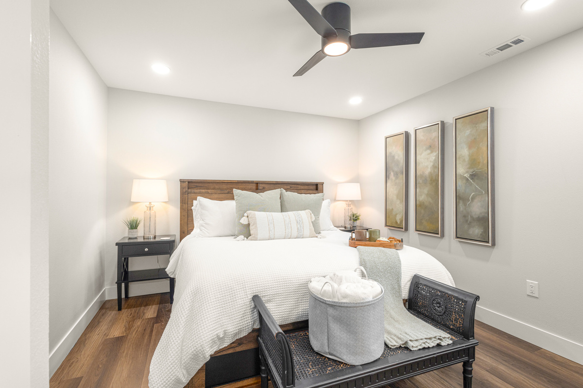 Master bedroom with mounted TV and desk with monitor