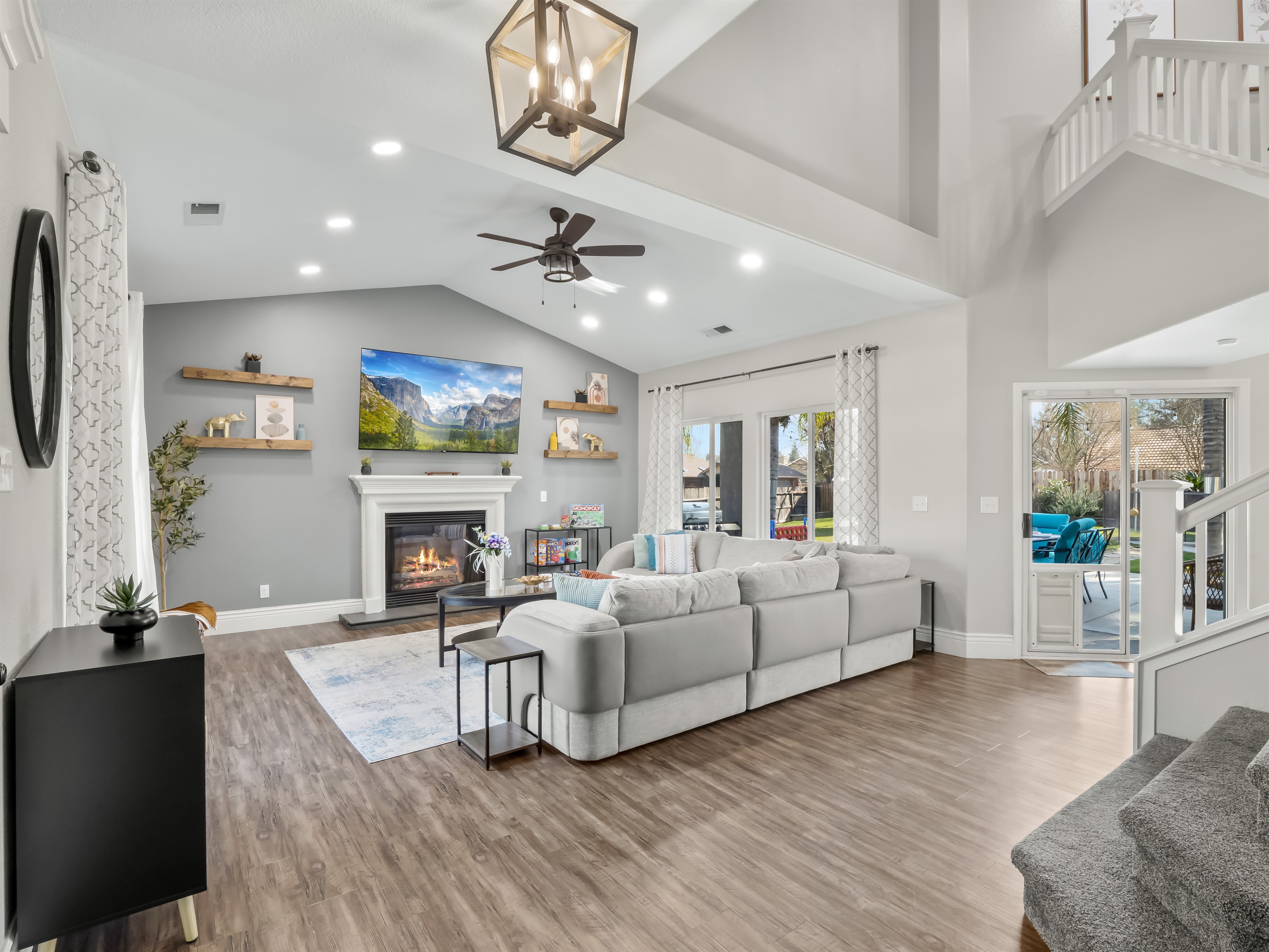 Spacious great room with vaulted ceilings, a cozy fireplace, and oversized sectional seating—perfect for family movie nights, board games, and gathering together after a fun day outdoors.