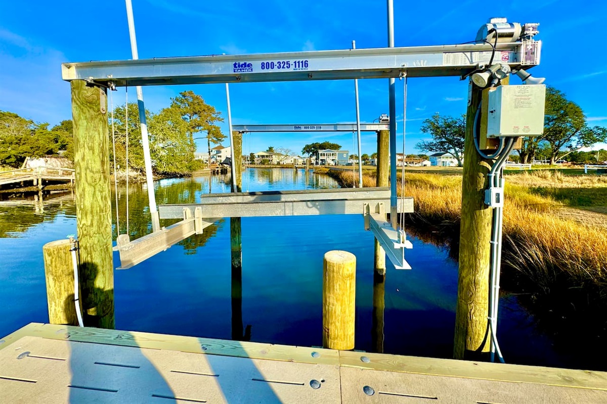 Private backyard dock with boat lift and fillet table, fenced-in backyard, fire pit with Adirondack chairs, hammocks, propane grill, picnic table, outdoor shower, expansive waterfront back deck with table and seating, neighborhood boat ramp and dock