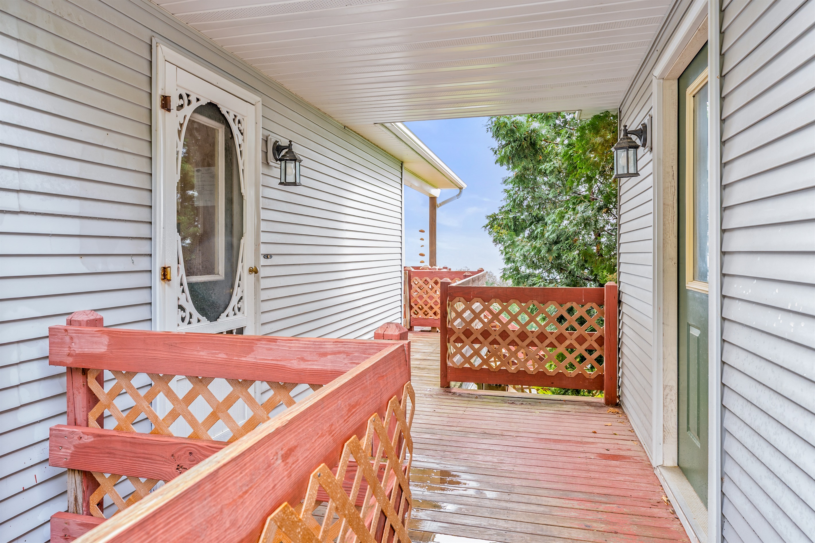 Covered porch entry with charming wood accents sets the tone for this cozy countryside retreat