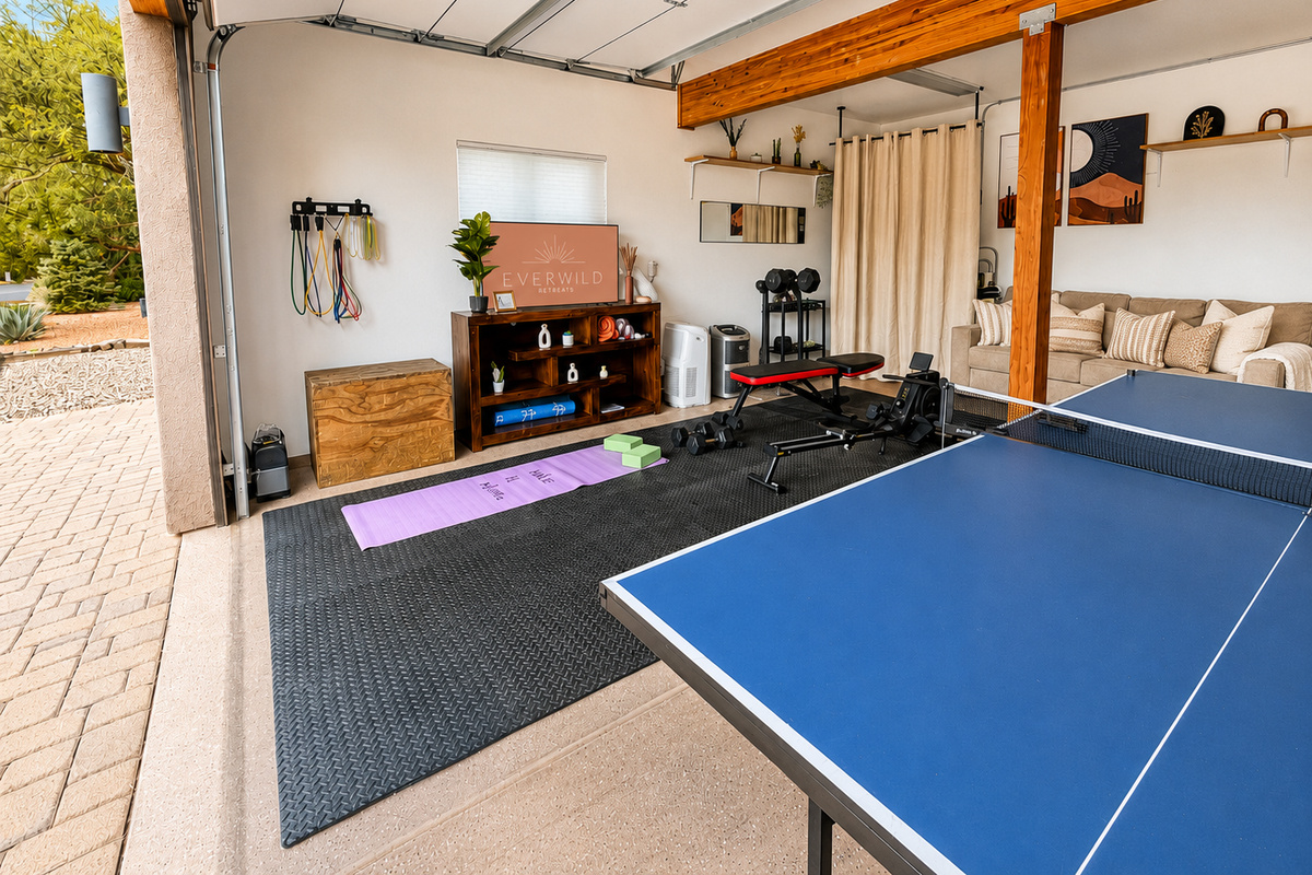 {CrossFit-Style Garage Gym + Game Room} Keep your routine going with 15–50 lb dumbbells, a rower, adjustable bench, resistance bands, yoga mats and blocks, plus plenty of open floor space—then challenge the group to a game of ping-pong.