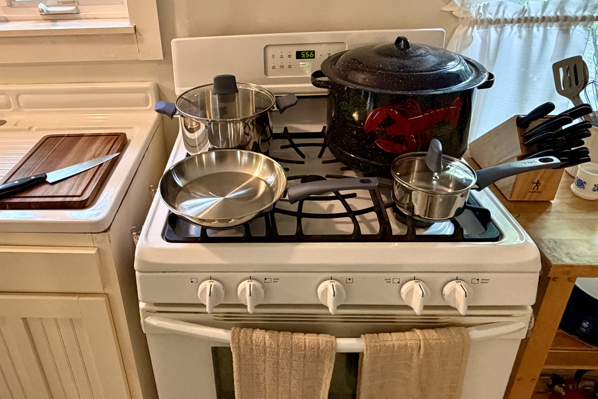 A fully equipped kitchen featuring gas cooking, a classic Maine lobster pot, brand-new stainless cookware, and a premium J.A. Henckels knife set. Everything a home chef needs to prepare fresh local seafood after a day in Acadia.