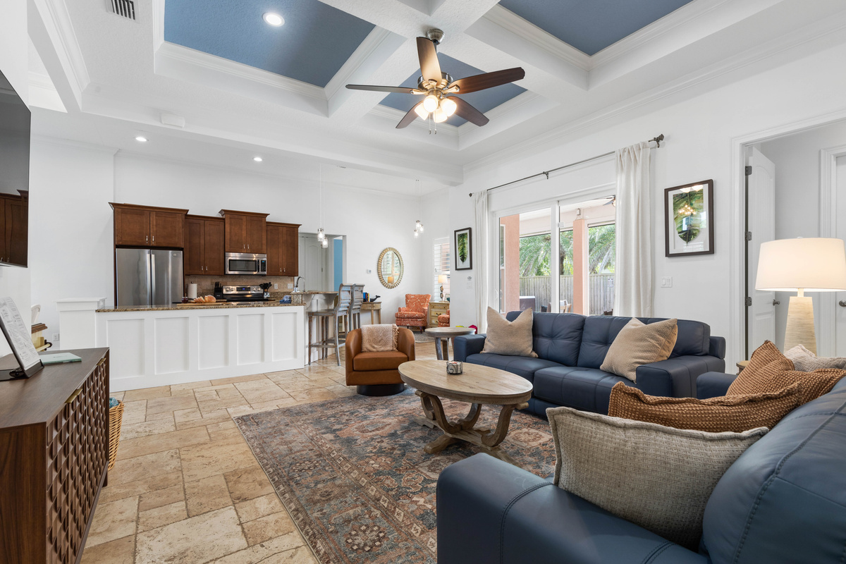 Open great room linking kitchen, sofas and patio sliders, so the cook stays part of every conversation.