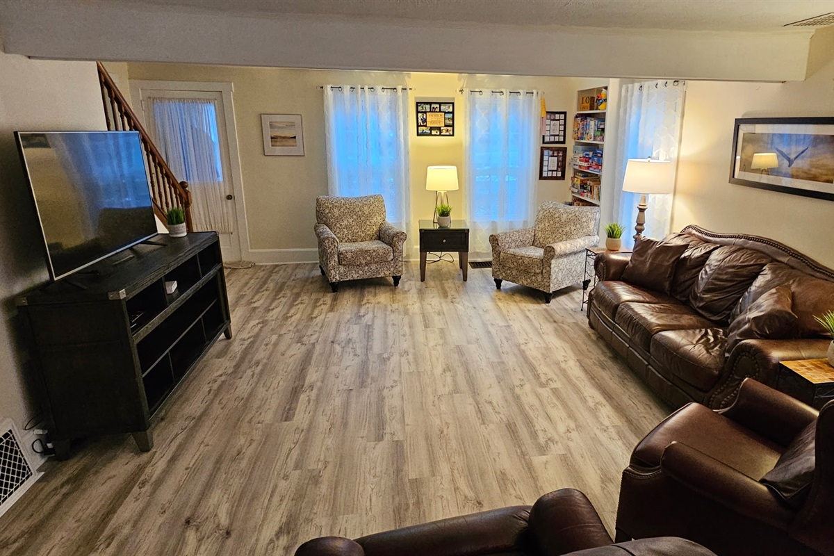 Large Living room with huge smart TV and comfy leather furniture.