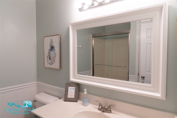 Newly renovated bathroom located in the hallway has a stall shower and beautiful beach tones. 