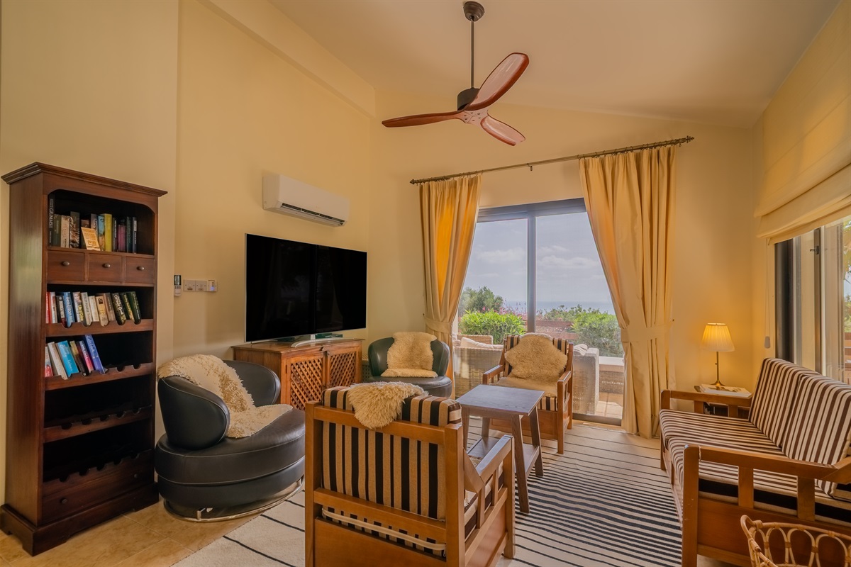 Living room with large-screen TV with international channels, bluray player, bluetooth-enabled sound system, and HDMI cable to connect your own device. Feel free to grab a book from our little library. High-speed internet/Wifi throughout the villa.