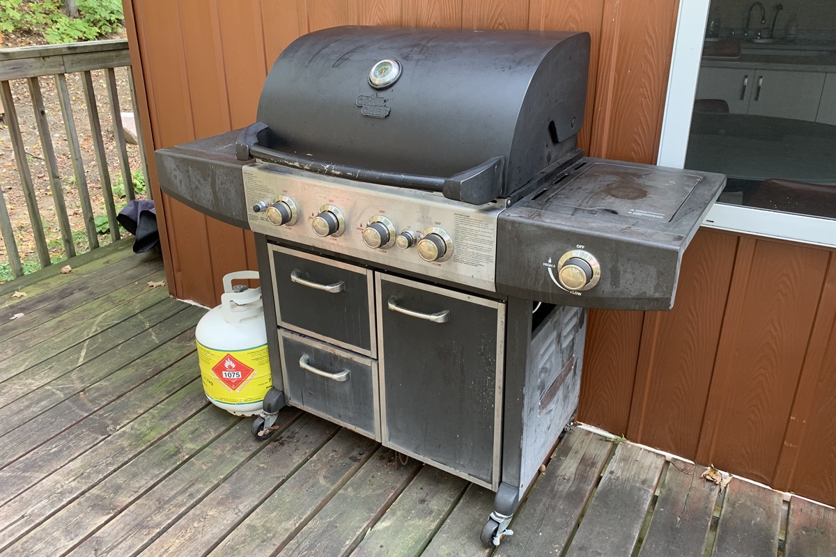 BBQ located conveniently on cottage side deck near entrance door and kitchen