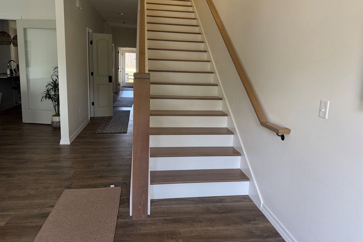 Open concept stairs and hallway make is a custom home