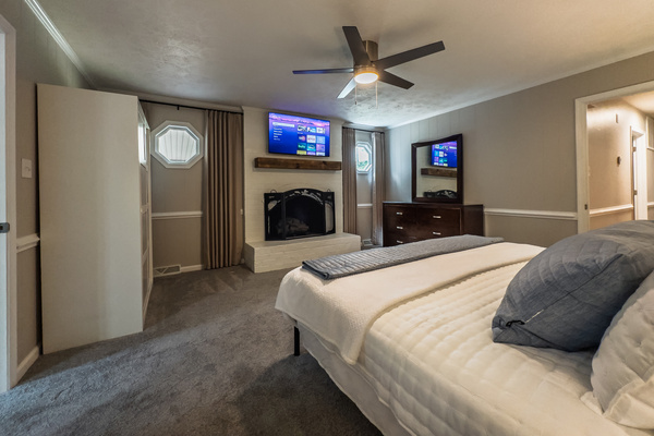 King bed, 55" Smart TV, ceiling fan, two led light nightstands with multiple charging ports, two multi light function lamps, blackout curtains, dresser, wardrobe closet, full length mirror, stylish brick fireplace - not in use.