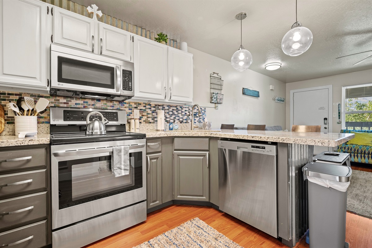 Modern kitchen with granite counters and stainless steel appliances.
