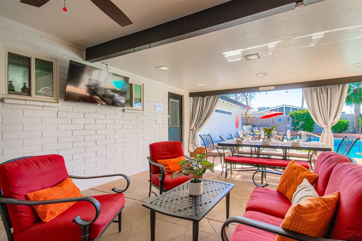 Outdoor seating for 4 in chairs and 10 at Dining table looking at the outdoor TV and pool