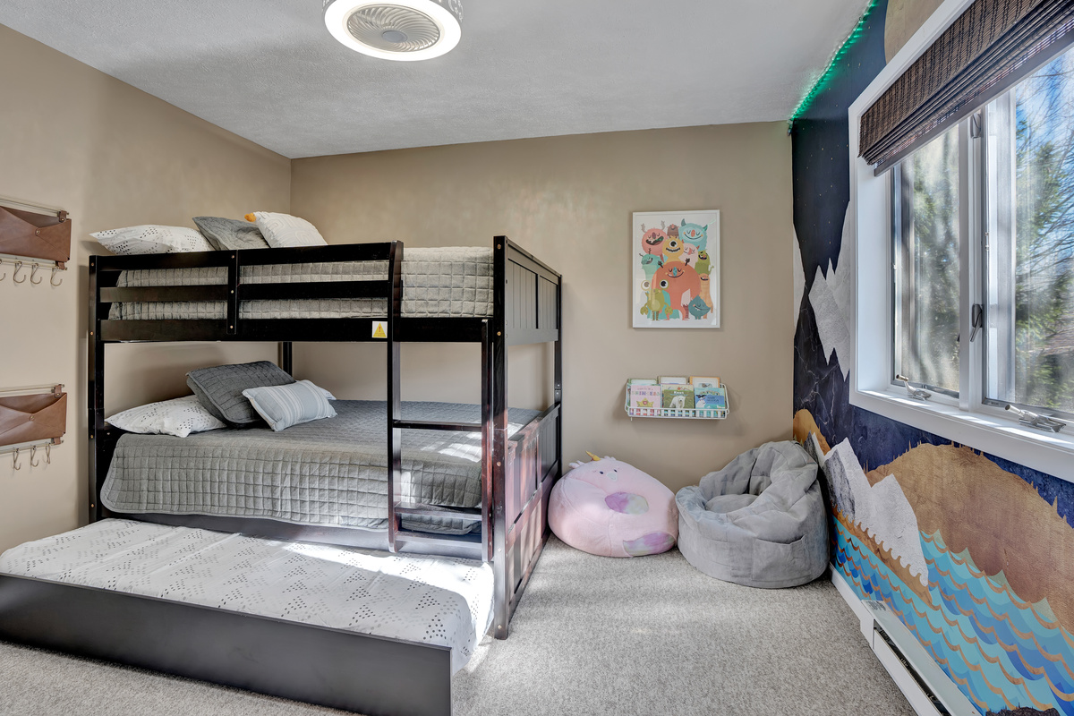 Full-size bunk beds, a twin trundle, and bean bags! This bedroom also has a TV and color-changing LED string lights.