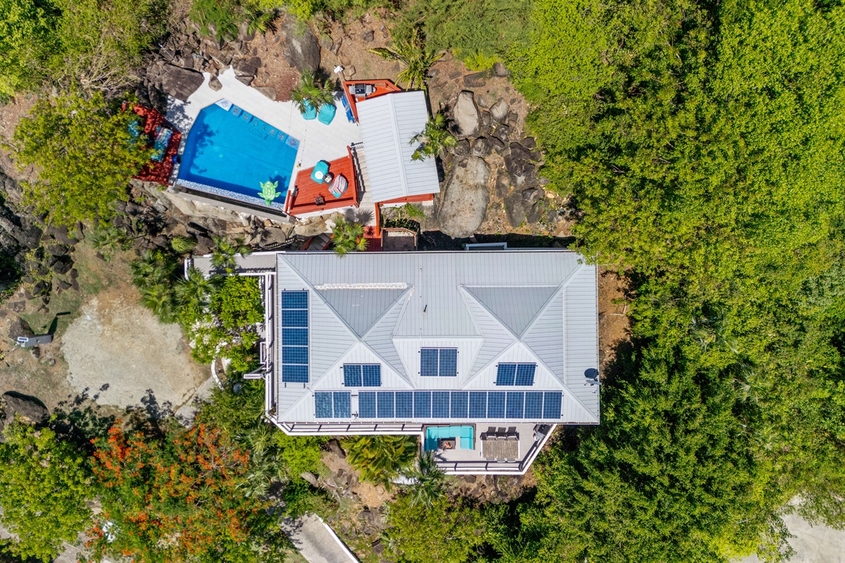 Overhead shot that gives an idea of the layout, parking area to the left, large pool in the back and wrap around deck.