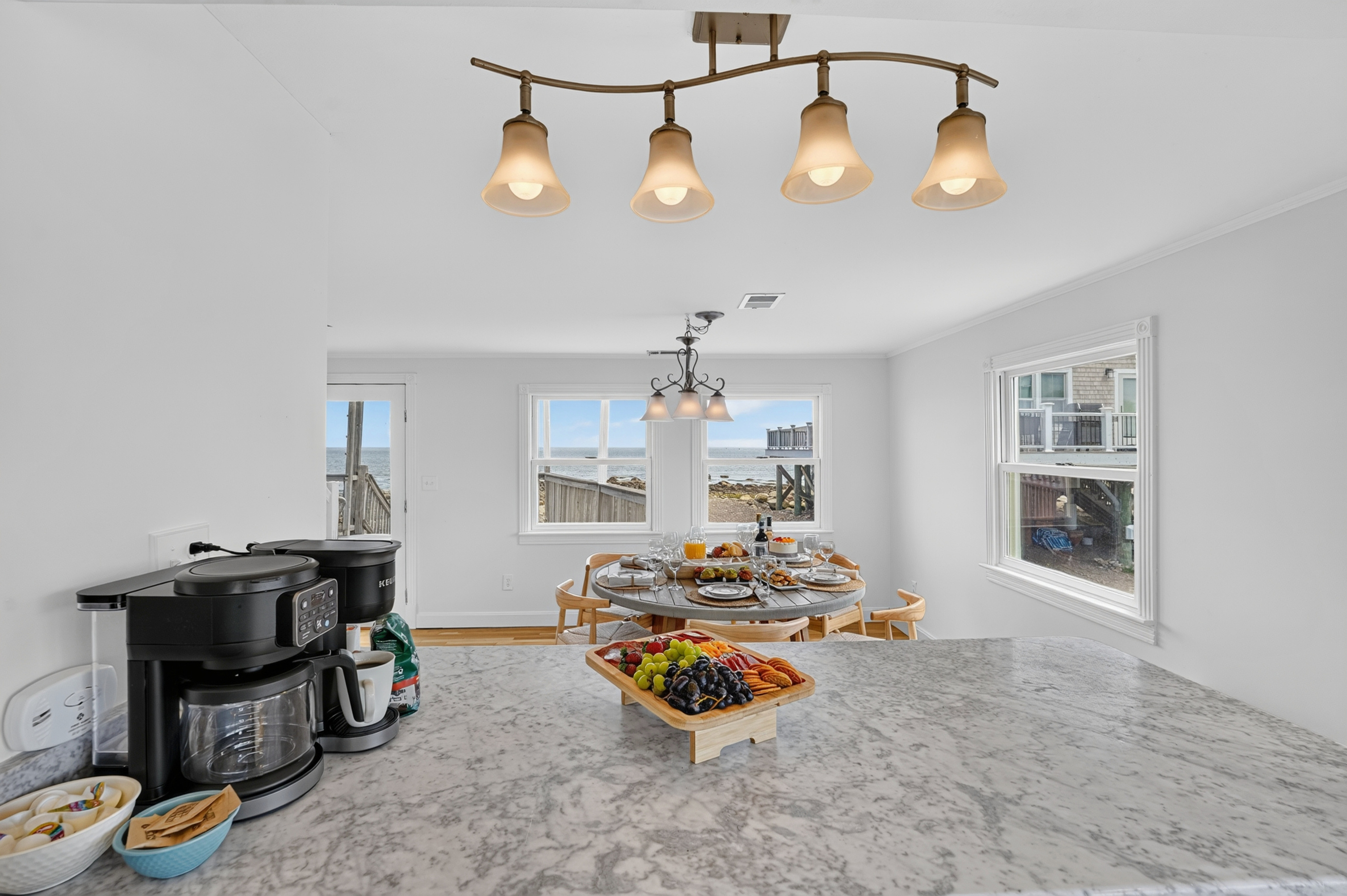 Enjoy breakfast or snacks at the spacious kitchen counter with natural light and coastal views nearby.