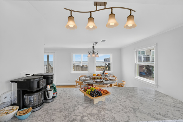 Enjoy breakfast or snacks at the spacious kitchen counter with natural light and coastal views nearby.