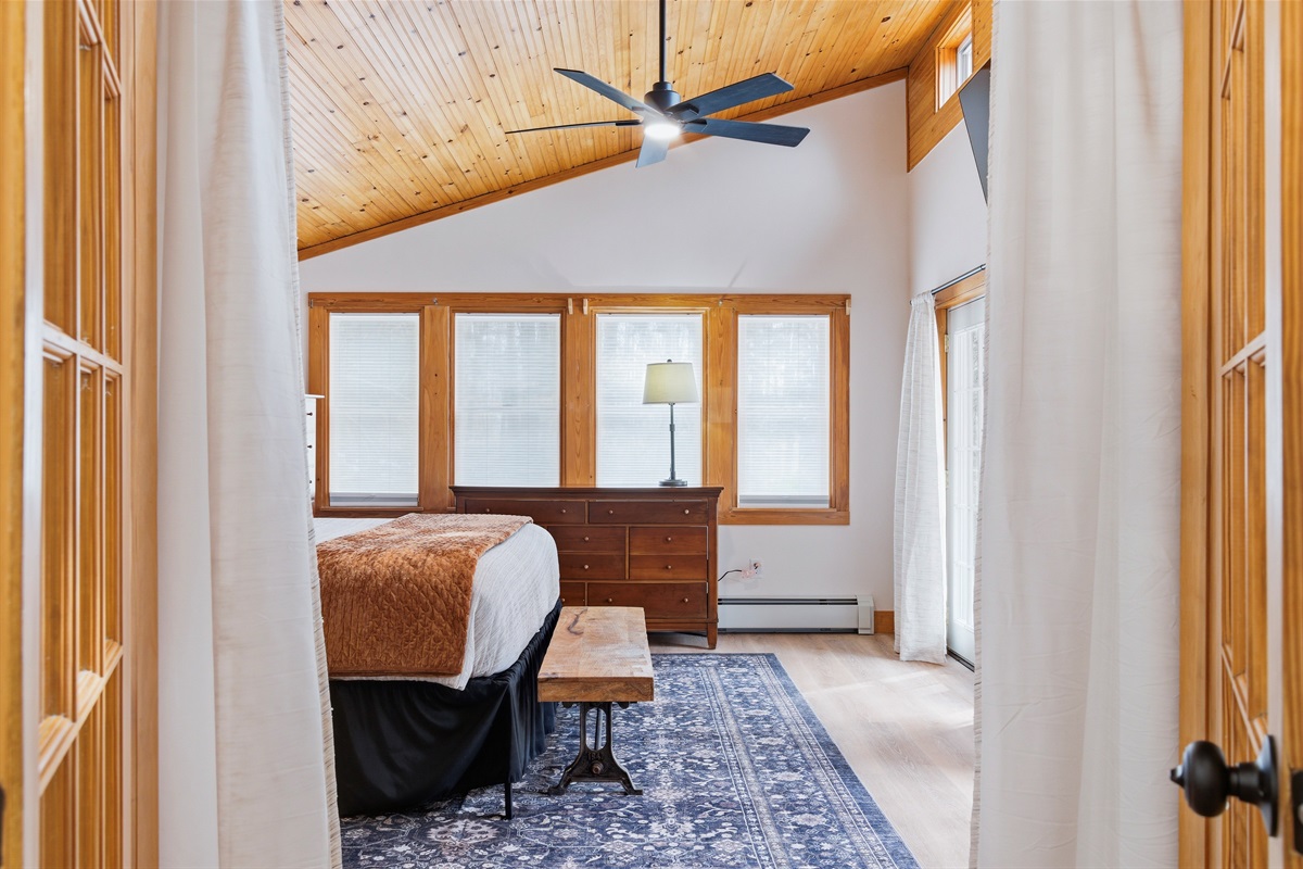 Wake up to the gentle mountain light through French doors in this spacious, lodge-inspired bedroom.