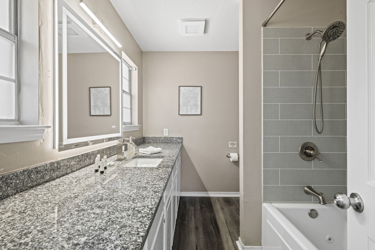 A spacious ensuite bath with granite counters, dual sinks, and a full tub-shower combo for unwinding after the beach.