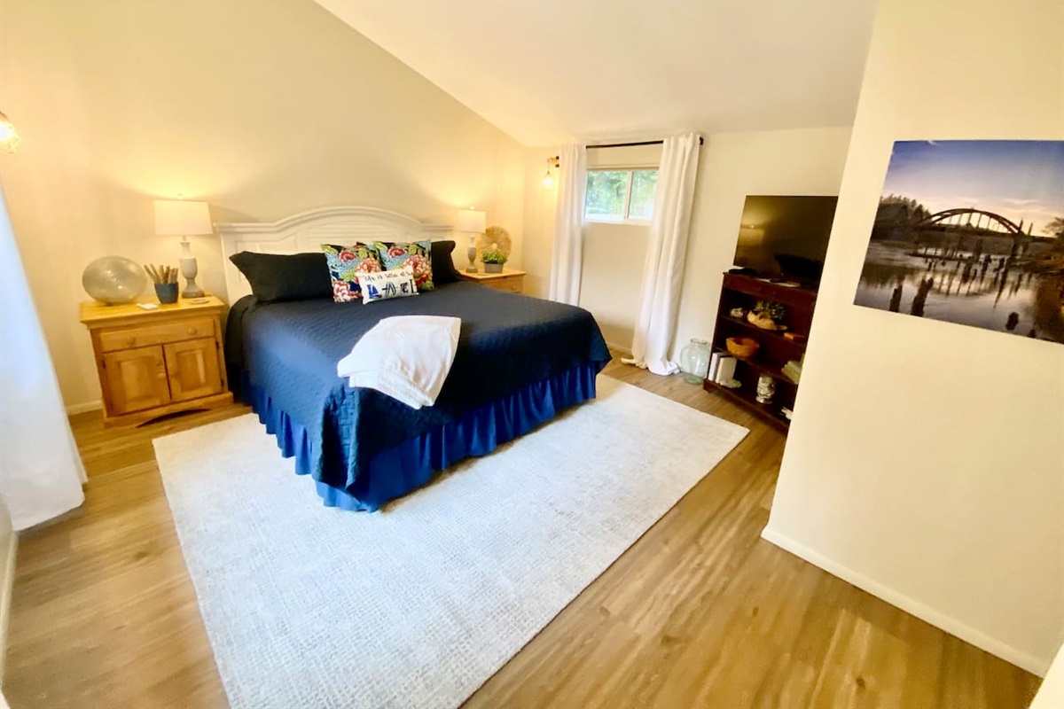 Primary bedroom with king bed and TV
