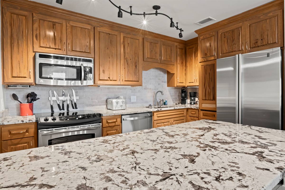 Cook with ease in the updated kitchen of our Cotton Bayou condo, featuring stainless steel appliances, an ice maker, a trash compactor, and a peninsula with extra seating. Fully stocked with all the essentials.