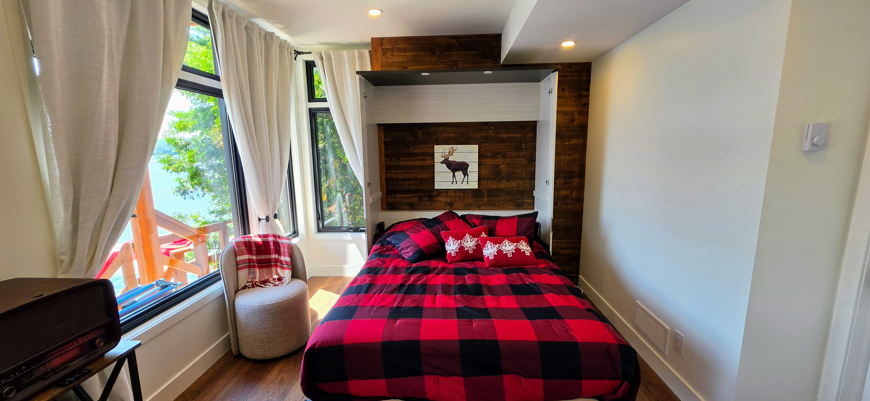 Lower level Murphy bed pulled out with view over deck and lake