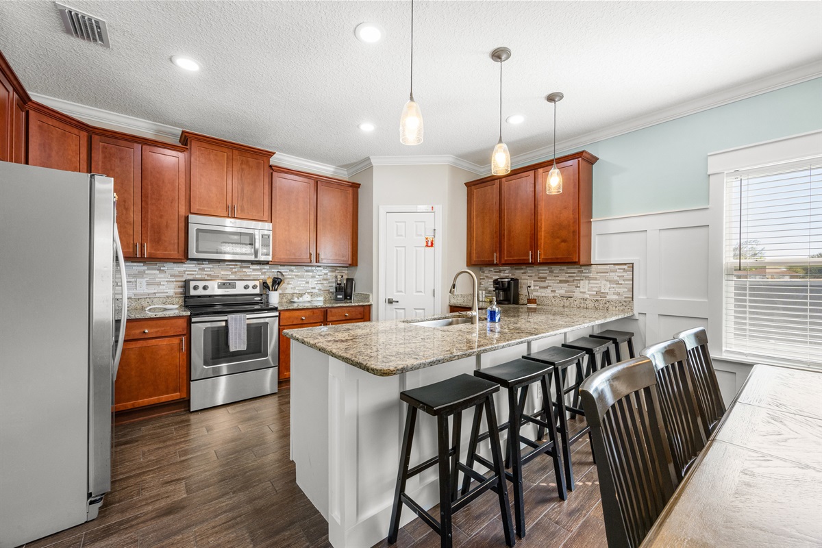 Kitchen overview with island seating and bright finishes