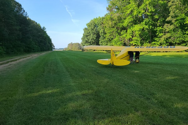 Piper cub parked on the runway