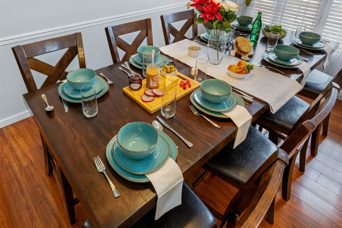 This stylish dining area features seating for eight, natural light, and charming tableware—ideal for memorable mealtime moments.