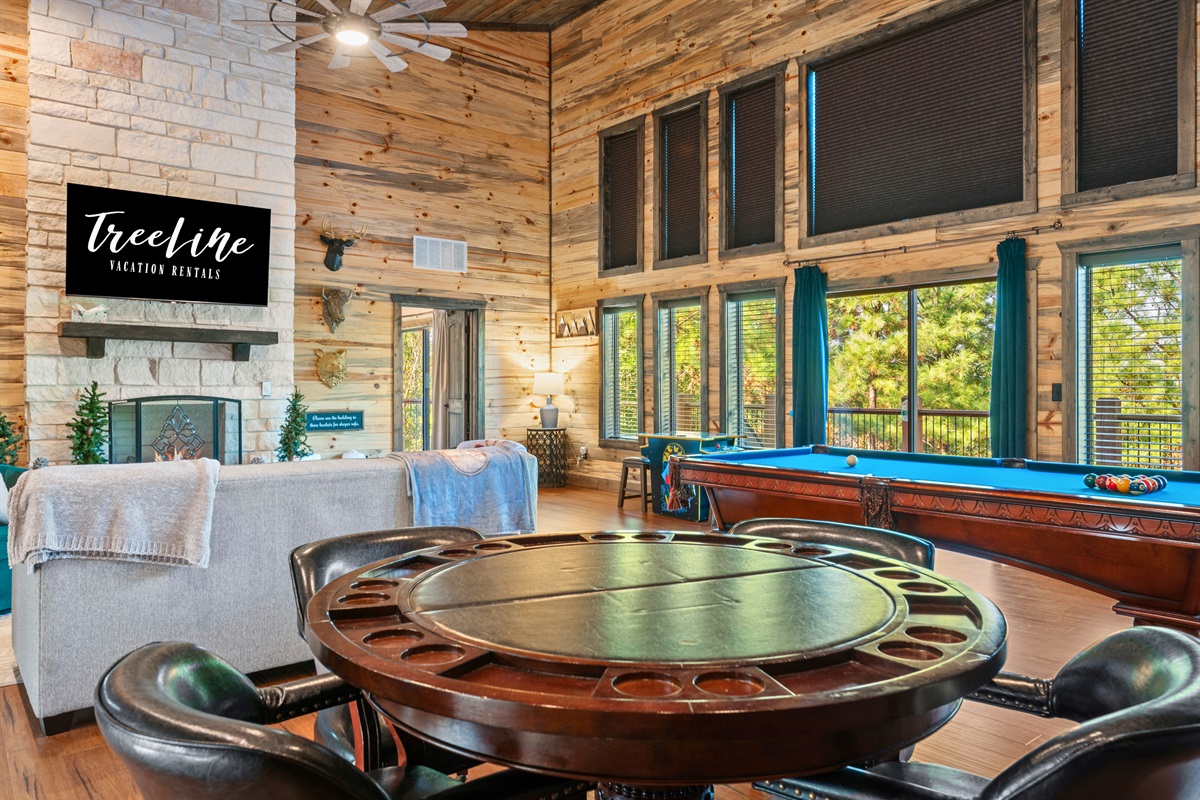 The open loft space includes comfy seating for hanging out or playing games, with a beautiful view over the main living area.